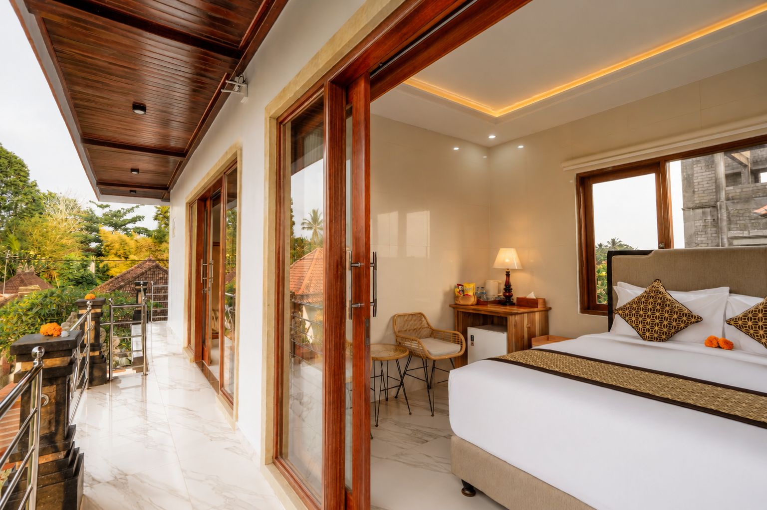 A hotel room with a large bed, a desk with a lamp, and a view of the outdoors.