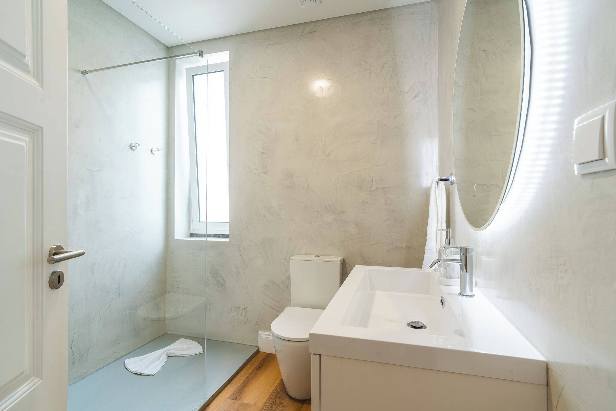 A modern bathroom with a shower, toilet, and sink.