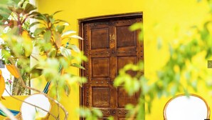Una puerta de madera con el número 14 sobre un muro amarillo.