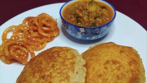 Un piatto di jalebi, una ciotola di curry e due fritture.