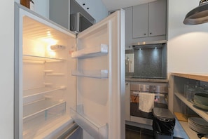 A modern kitchen with a built-in refrigerator, oven, and microwave.