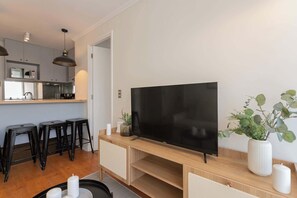 A modern kitchen with a microwave, a sink, and a dining area with stools.