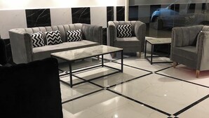 Un salón moderno con un juego de sofá, una mesa de centro y un ventanal con vista a un coche.
