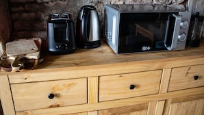 A kitchen counter with a microwave, coffee maker, and kettle. - Large apartment with raised garden in the heart of Burgundy (Montcenis)