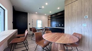Une cuisine moderne avec des meubles de rangement noirs, une table à manger en bois et six chaises.