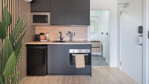 A modern kitchen with a built-in oven, a dishwasher, and a countertop with various appliances.