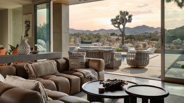 Un salon moderne doté d’une grande porte vitrée donnant sur une terrasse extérieure.