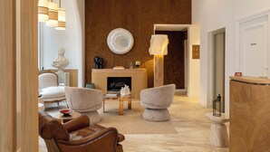A modern living room with a fireplace, leather sofa, and contemporary furniture. - Madame Drouot & Spa - Opéra (Paris)