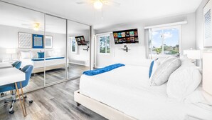 A modern bedroom with a large bed, a desk, and a chair. - Tranquil Escape Pool Hot Tub Game Room (San Diego)