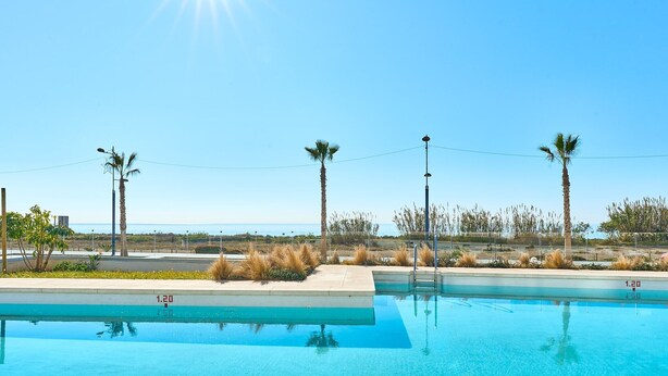 A clear blue sky, a swimming pool, and palm trees. - Apartment 'Db01 Duna Beach Casa Zen' with Shared Pool, Wi-Fi and Air Conditioning (Torrox)
