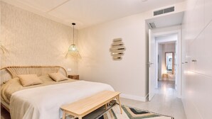 A bedroom with a bed, bedside table, hanging light fixture, and a geometric wall decoration. - Apartment 'Db01 Duna Beach Casa Zen' with Shared Pool, Wi-Fi and Air Conditioning (Torrox)