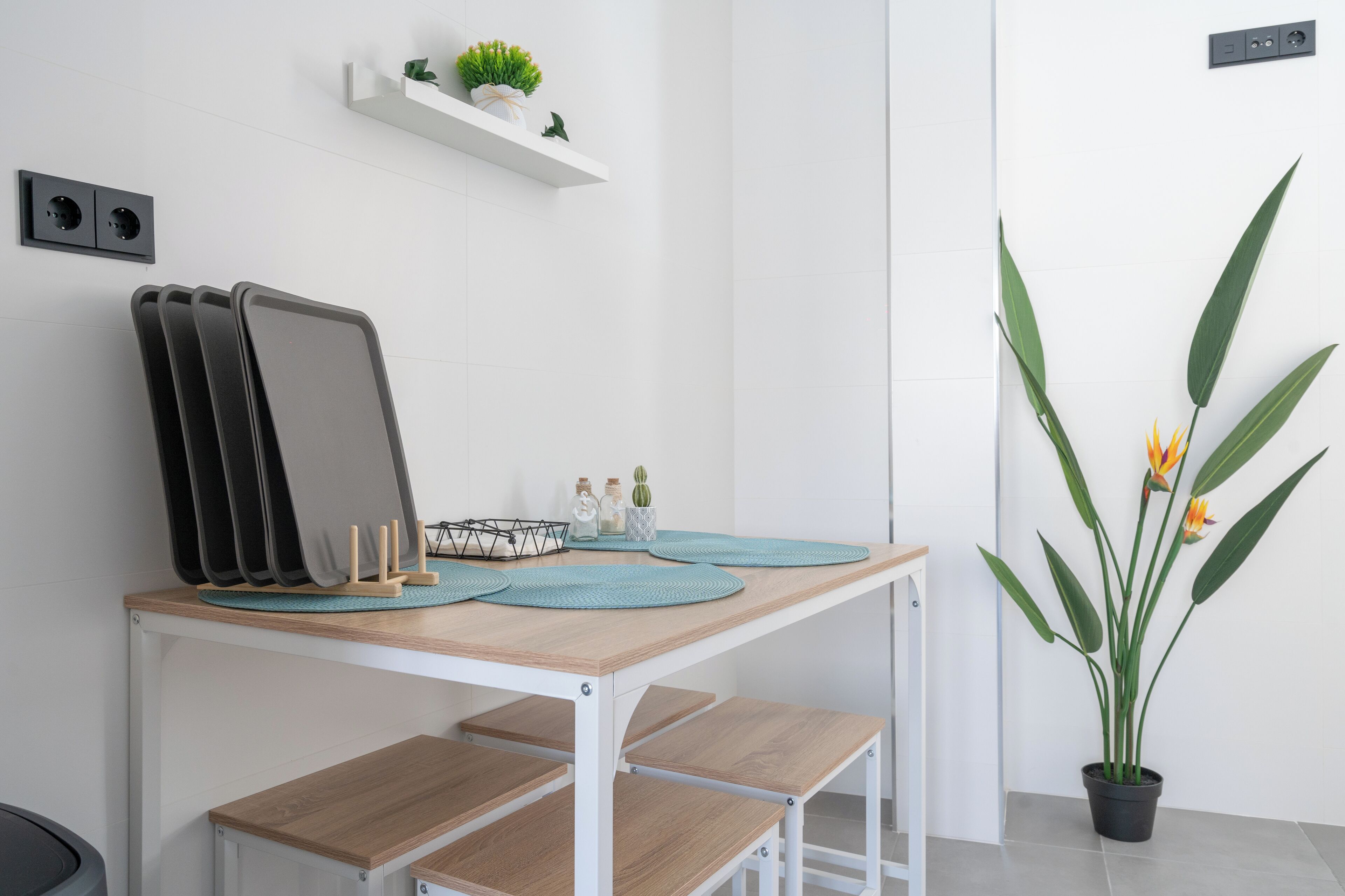 Une cuisine moderne avec une table en bois, un tableau noir et une plante en pot.