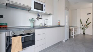 A modern kitchen with a built-in oven, microwave, and sink.