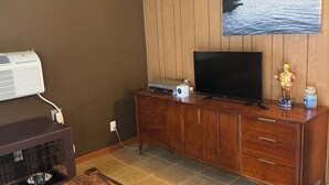 A living room with a wooden cabinet, a television, and a coffee table. - Bellawood Resort #5 - Lake Cabin with boat slip (Greers Ferry)