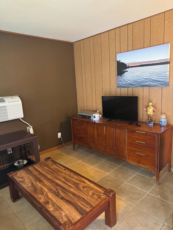 A living room with a wooden cabinet, a television, and a coffee table.
