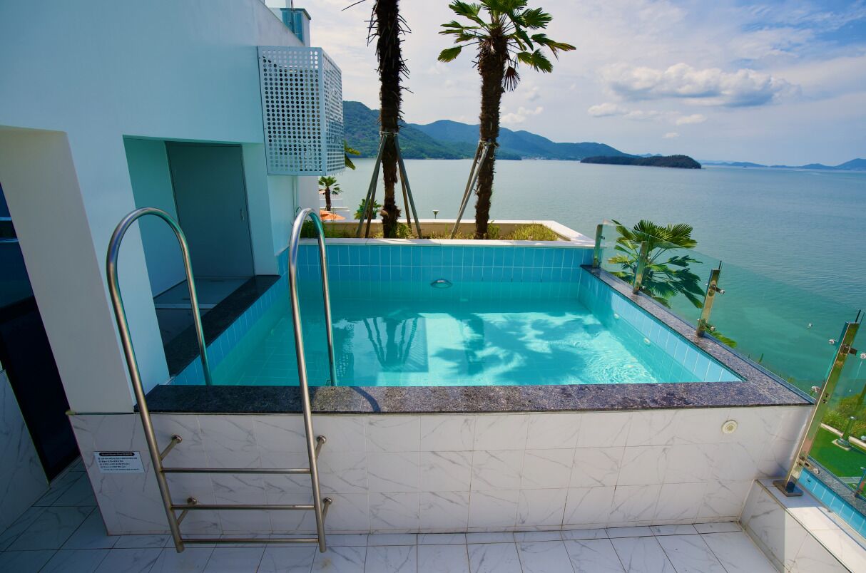 Piscina infinita en la azotea con vistas despejadas al mar y a las montañas.