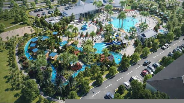Vue aérienne d’un complexe hôtelier doté de plusieurs piscines, de palmiers et d’un parking.