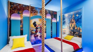 Une chambre d’enfant avec deux lits, une fresque représentant Mickey et Minnie Mouse, et une scène de château.