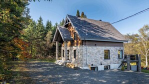 Ein Haus aus Stein mit geneigtem Dach, Holzfassade und steinernen Fundament.