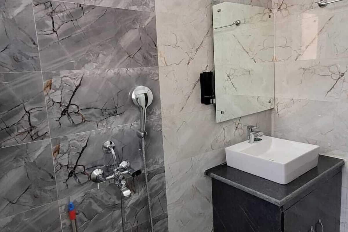 A bathroom with a shower, sink, and vanity.