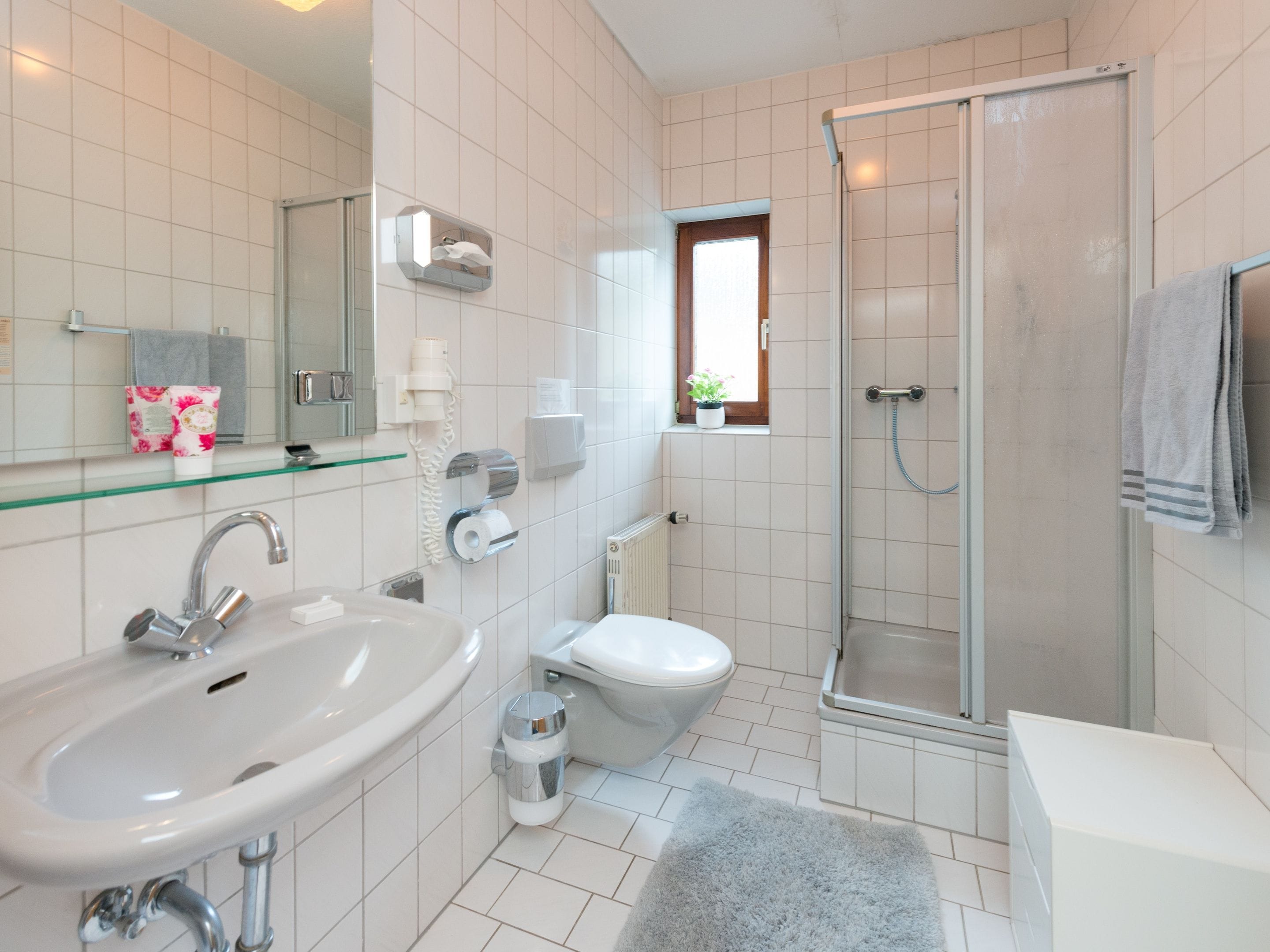 A modern bathroom with a sink, toilet, and shower.