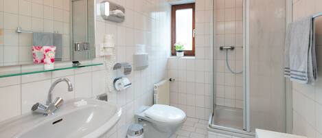 A modern bathroom with a sink, toilet, and shower.