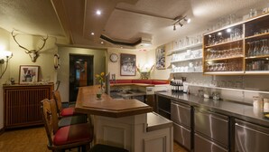 Een keuken met een bar, roestvrijstalen apparatuur en een klok aan de muur.