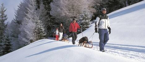 Paisaje nevado con personas esquiando y caminando.