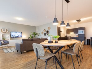 Cozy living space with a round dining table and comfortable seating for four, perfect for socializing and relaxation.