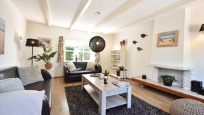 Ein modernes Wohnzimmer mit einer Couch, einem Couchtisch und einem Kamin.