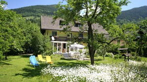 A house with a garden, outdoor seating, and a view of the mountains. - Cozy Apartment in Feld am See Near Ski Slopes (Feld am See)