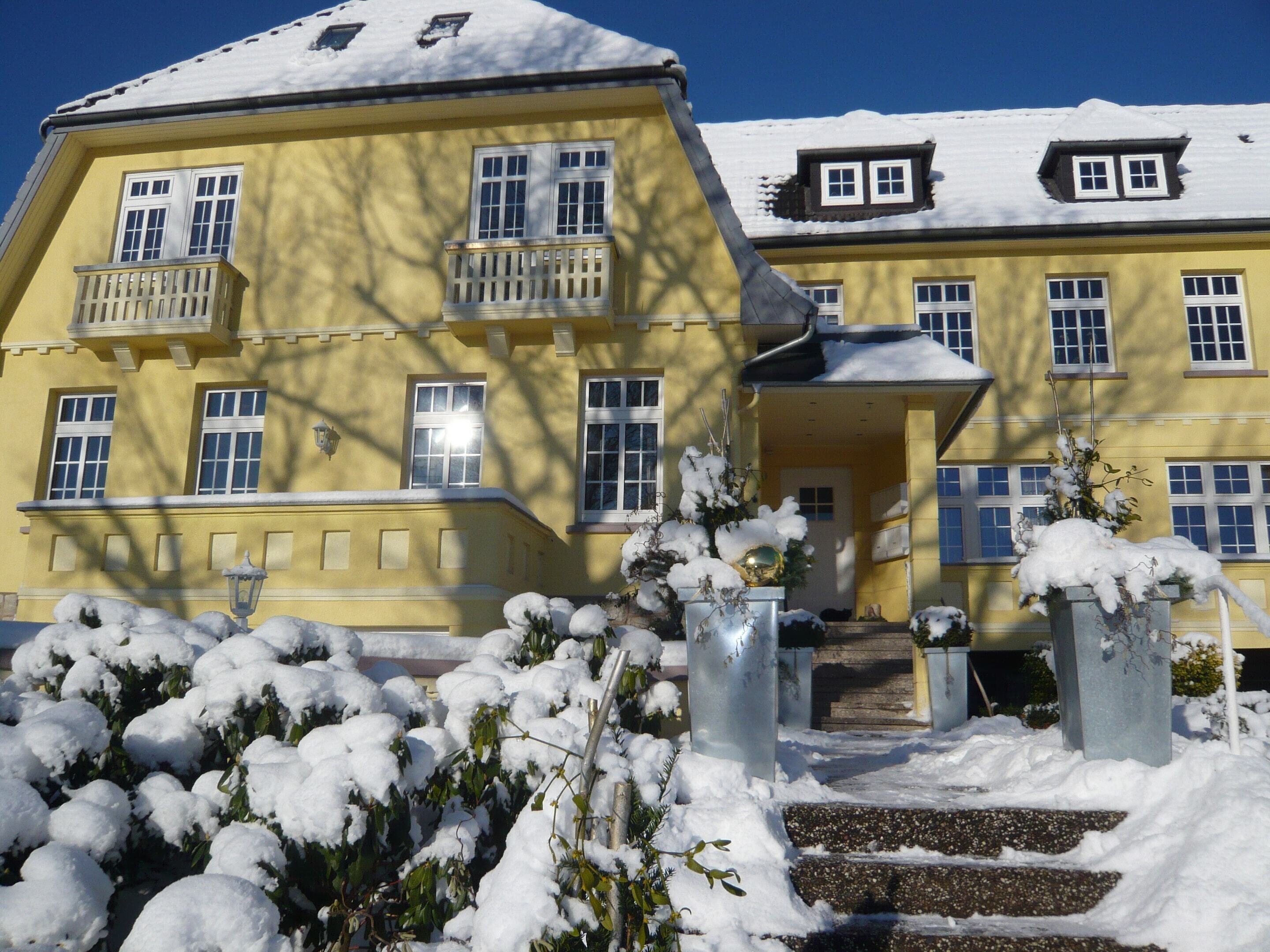 A yellow building with multiple windows and a balcony.