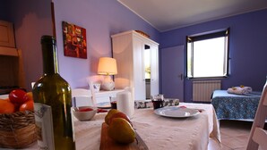 A room with a dining table set with food and drinks, a bottle of wine, a lamp, and a bed with a blue bedspread. - Farmhouse With Swimming Pool in Casperia (Casperia)
