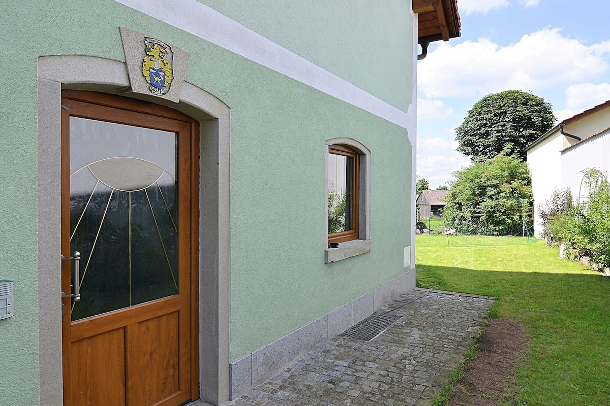 A building with a green facade, a wooden door, and a small window.