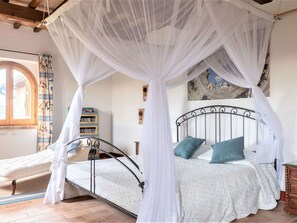 A bedroom with a four-poster bed, a canopy, a window with curtains, a bookshelf, and a painting on the wall. - Beautiful Villa in San Giovanni del Pantano With Pool (Perugia)