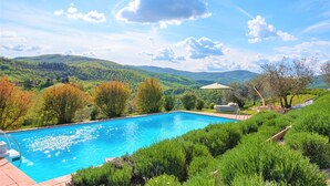 A swimming pool with a view of green hills and trees. - Beautiful Villa in San Giovanni del Pantano With Pool (Perugia)