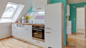 A modern kitchen with white cabinetry, a built-in oven, and a window above the sink. - Pleasant Holiday Home in Zierow Near Sea (Zierow)