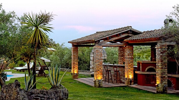 A brick outdoor patio with a pergola, stone columns, and a brick oven. - Scenic Villa in Paleokastrites With Sauna (Corfu)