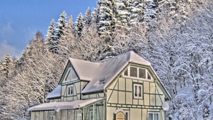A traditional chalet-style building with a steep roof, large windows, and a sign indicating it is a guesthouse. - Deluxe Holiday Home in Brilon-wald Near Ski Area (Brilon)