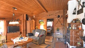 A cozy wooden cabin interior with a television, sofa, and dining table. - Detached Wooden House Near Bad Wildungen (Haina)