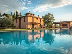 A large swimming pool with a building in the background. - Pleasant Villa in Peccioli With Private Swimming Pool (Peccioli)