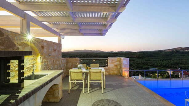 A rooftop terrace with a pool, stone walls, and a table with chairs. - Splendid Villa in Achlades With Private Pool Near Bali (Mylopotamos)