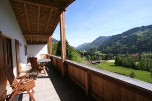 A wooden balcony with a view of a valley and mountains. - Chalet in Niederndorf Near Kufstein With Balcony (Niederndorferberg)