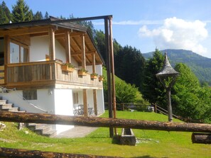 A chalet-style building with a wooden balcony, a stone staircase, and a mountain backdrop. - Chalet in Niederndorf Near Kufstein With Balcony (Niederndorferberg)