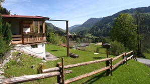Una cabaña de madera con balcón que da a un valle y montañas.