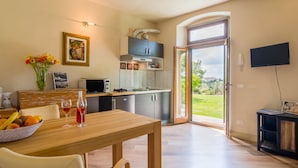 A modern kitchen with a dining area, a TV mounted on the wall, and a view of the outdoors. - Beautiful Holiday Home in Vinci With Swimming Pool (Vinci)