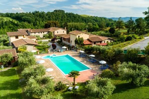 A pool area with a rectangular pool, lounge chairs, and umbrellas. - Farmhouse in Perugia With Swimming Pool (Perugia)