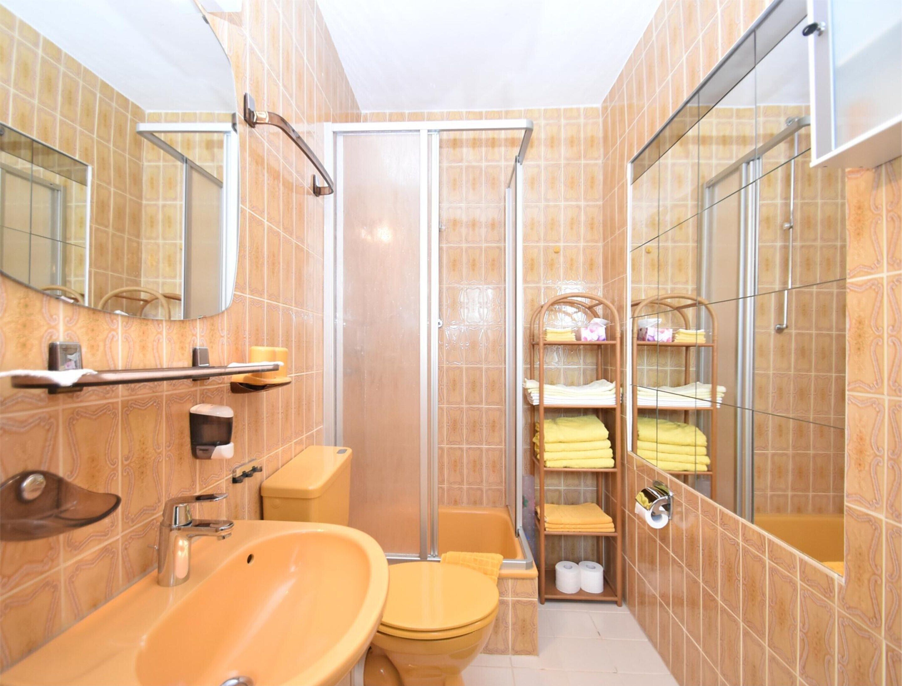 A bathroom with a sink, toilet, and shower area.