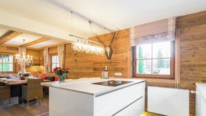 Una cucina moderna con isola centrale, pareti in legno e un'ampia finestra.