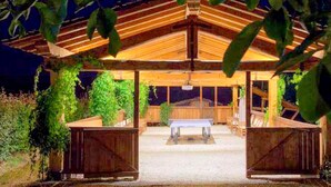 A wooden pavilion with a bench and a table in the center, surrounded by greenery. - Comfortable Cottages in Loro Ciuffenna (Terranuova Bracciolini)